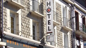 Um hotel com fachada de pedra, várias varandas e uma placa indicando que é um hotel e restaurante.