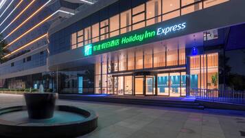 Um hotel Holiday Inn Express com fachada moderna, grandes janelas e entrada bem iluminada.