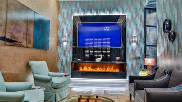 Una sala de estar moderna con chimenea, televisor de pantalla plana y asientos cómodos.
