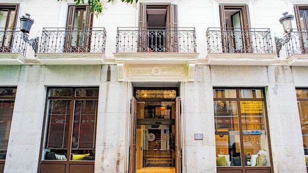 A building with a central entrance, large windows, and balconies with wrought iron railings. - Soho Boutique Opera (Madrid)