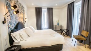 A hotel room with a large bed, a desk, a chair, and a view of the outside. - Soho Boutique Opera (Madrid)