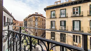 A view of a narrow street lined with multi-story buildings, balconies, and a clear sky. - Soho Boutique Opera (Madrid)