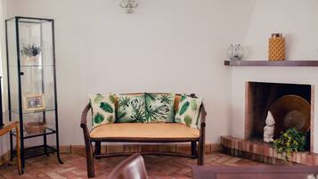 A living room with a wooden bench, a glass display unit, a fireplace, and a wall-mounted light fixture.
