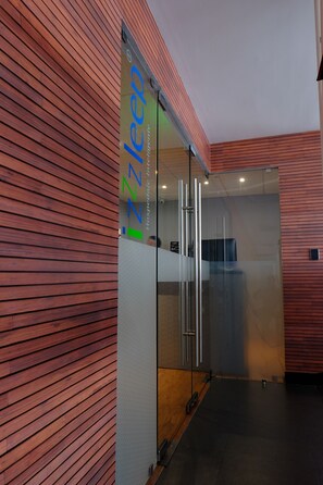 Eine moderne Hotelhalle mit Holzvertäfelung und einer Glastrennwand.