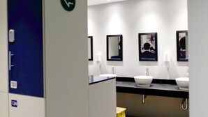 Ein modernes Badezimmer mit zwei Waschbecken, einem Spiegel und einer Toilette.