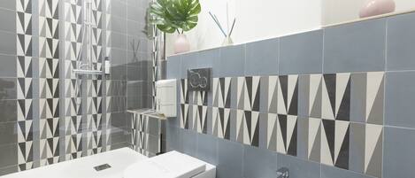 A modern bathroom with a shower, toilet, and sink.