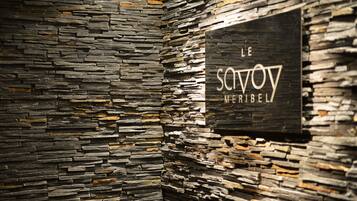 A stone wall with a sign that reads "Le Savoy Meribel."