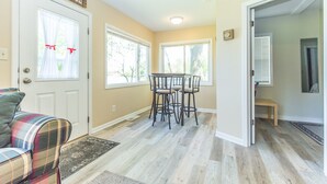 A room with a plaid sofa, a dining table with chairs, and a door labeled "LAKE HOUSE". - Lakehouse with Pontoon, Deck, Firepit, Paddle Boards, Grill & more INCLUDED!!  (Valparaiso)