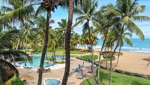 Un resort con piscina, sillas de descanso y palmeras.