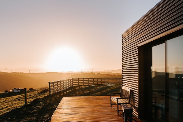A wooden deck with benches overlooking a scenic landscape with wind turbines in the distance. - 360o views incl. The Prom, Bass Strait and Strzelecki Ranges (Hazel Park)