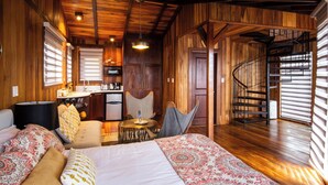 A cozy room with a bed, a desk, a chair, and a spiral staircase. - Lucero Residences Golf & Wellness Resort (Jaramillo)
