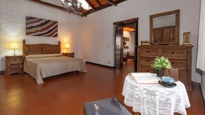 A bedroom with a bed, bedside tables, a dresser, a mirror, and a small table with a book and a plant. - GC0242 Holiday cottage with private pool in Santa Lucía (Santa Lucía de Tirajana)