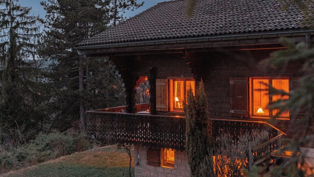 A rustic cabin with a stone patio, wooden deck, and a small outdoor seating area. - Charming lux chalet, views, comfort, escape, Samoens Valley, peaceful log fire (Mieussy)