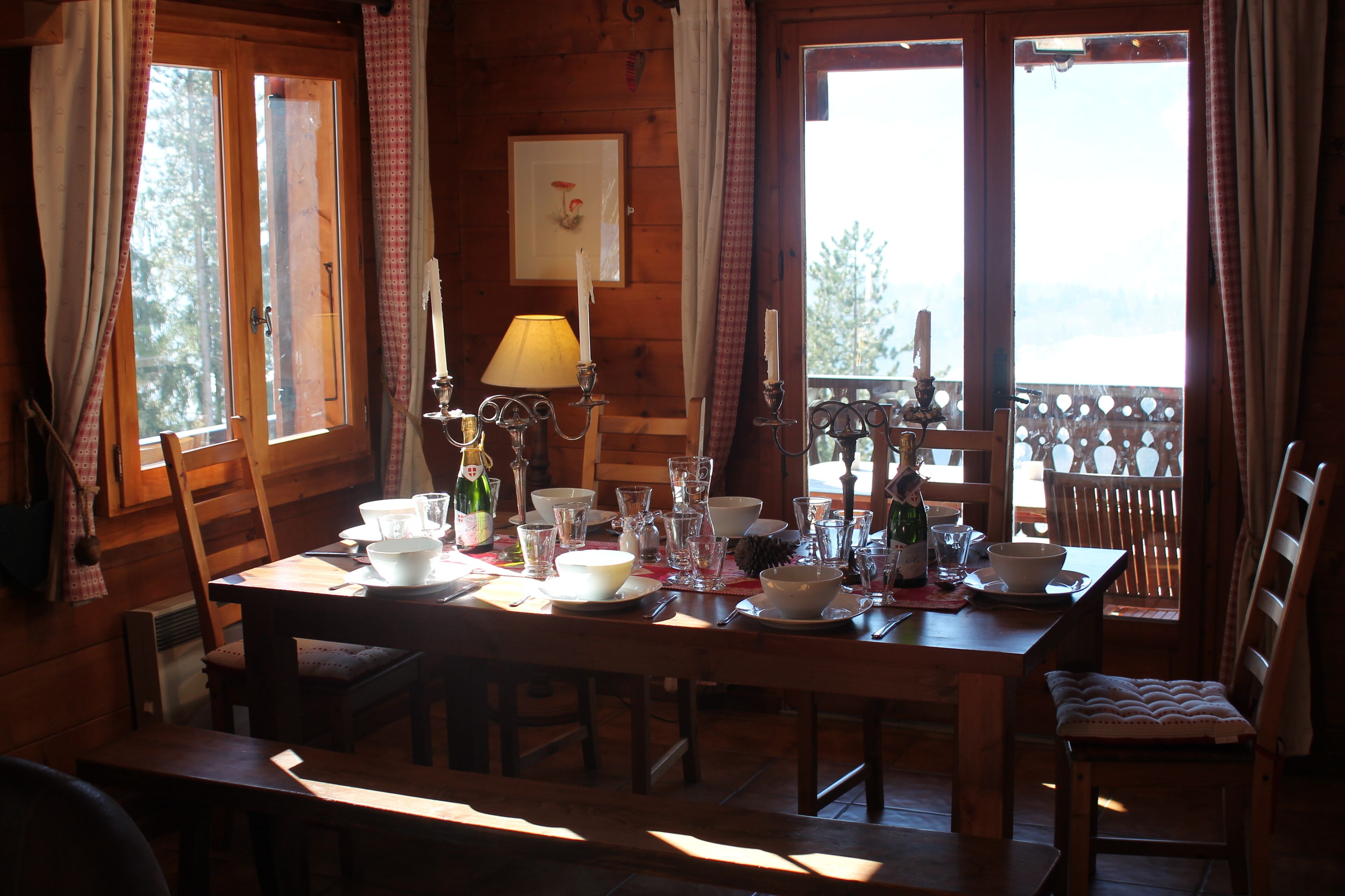 A wooden dining table set with various dishes, glasses, and a candle.