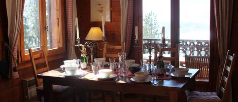 A wooden dining table set with various dishes, glasses, and a candle.