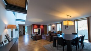 Amplia sala de estar con mesa de comedor, sofás y un gran ventanal con vistas.