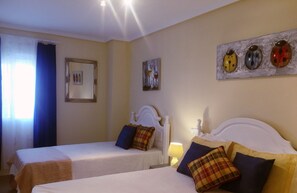 A bedroom with two beds, a view of the pool, and artwork on the walls. - VILLA 3 BEDROOM- PRIVATE POOL CLOSE TO AMENITIES-PERFECT FOR A RELAXING HOLIDAY (el Gran Alacant)