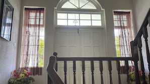 A staircase with a wooden handrail leading to a white door with a glass panel. - Villa, 4 beds, 3 bathrooms, 1 minute to beach by car or 10 minute stroll (Westmoreland)