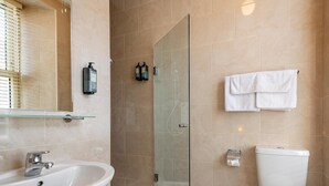 A bathroom with a glass-enclosed shower, a white sink, and a toilet. - A 2 bed apartment that sleeps 4 guests  in 2 bedrooms (kenmare)