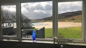A kitchen with a window overlooking a beach and hills. - Mellon Udrigle "Heaven on Earth",Luxury 6 bed Beach House, sea views (Scottish Highlands)