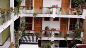 Un immeuble à deux étages doté de balcons, chacun ayant des portes et des fenêtres en bois.