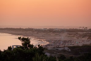 Ein Strand mit Menschen und Gebäuden im Hintergrund.