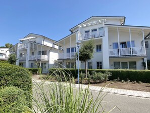A multi-story hotel with balconies, a clear sky, and well-maintained landscaping. - P: Villa Karola Whg. 14 with balcony - Villa Karola Whg. 14 with balcony (Göhren)