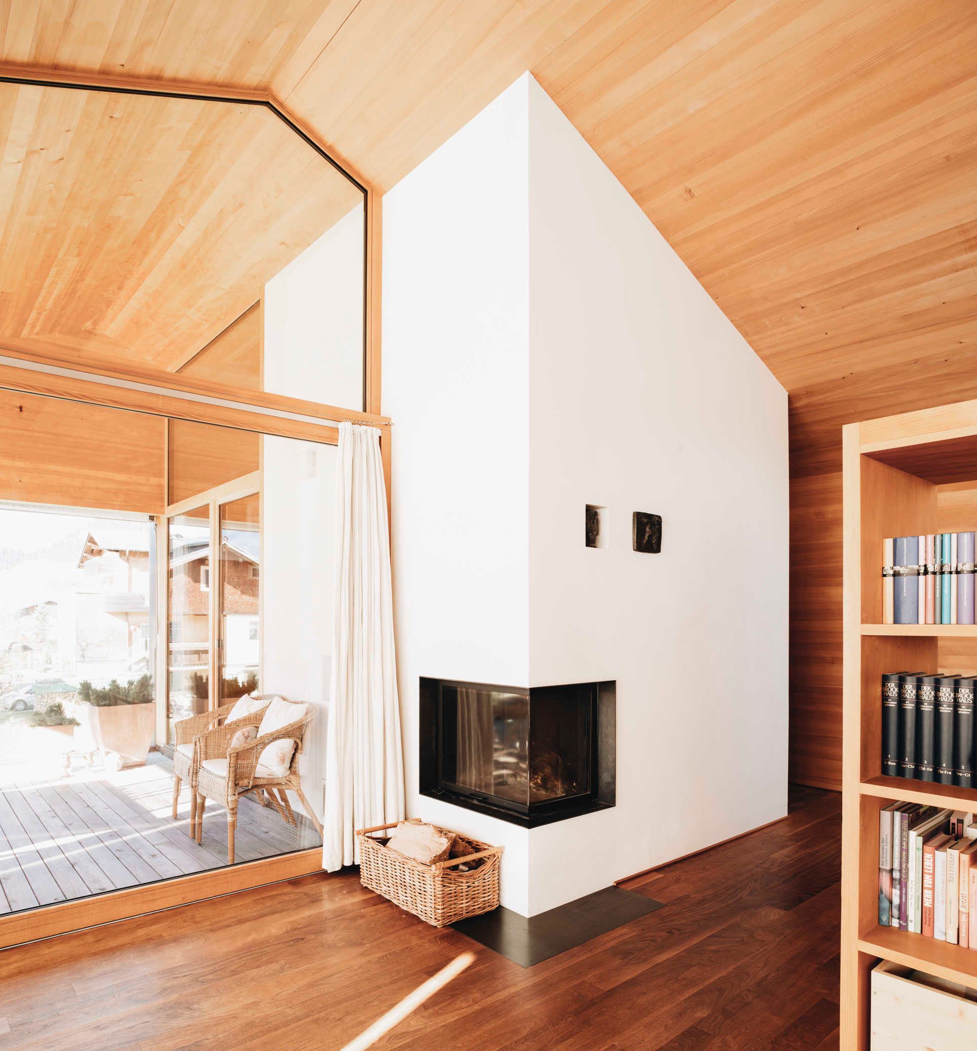 A modern interior with a fireplace, wooden flooring, and a bookshelf.