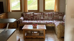 Una stanza accogliente con un divano, un tavolo in legno e una TV.