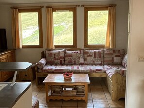 Una habitación acogedora con un sofá, una mesa de madera y un televisor.