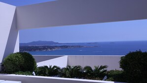 A balcony with a view of the sea and distant land.