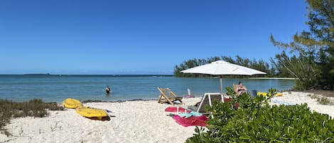 Na praia, espreguiçadeiras, toalhas de praia 