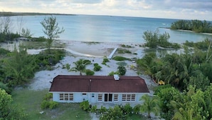 A coastal property with a single-story house, a sandy beach, and a view of the ocean. - Your Tropical Beach Vacation! (Morgans Bluff)