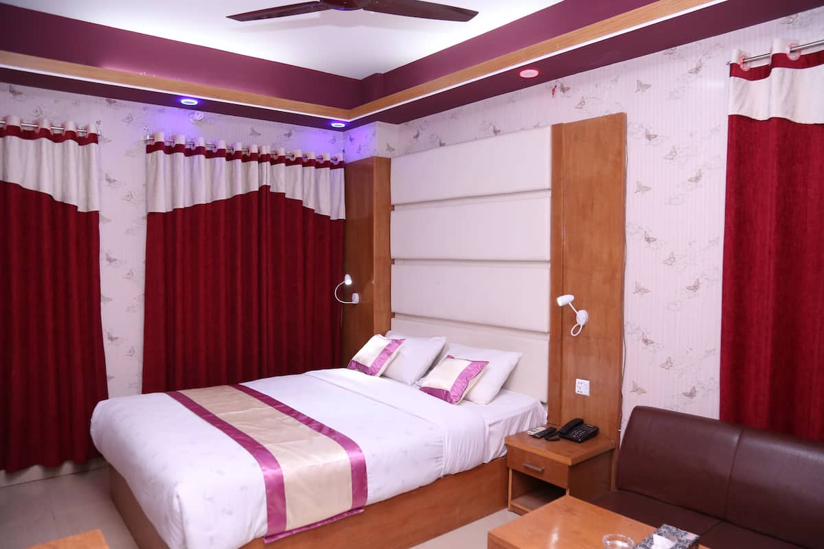 A neatly arranged bedroom with a bed, bedside table, and a seating area.