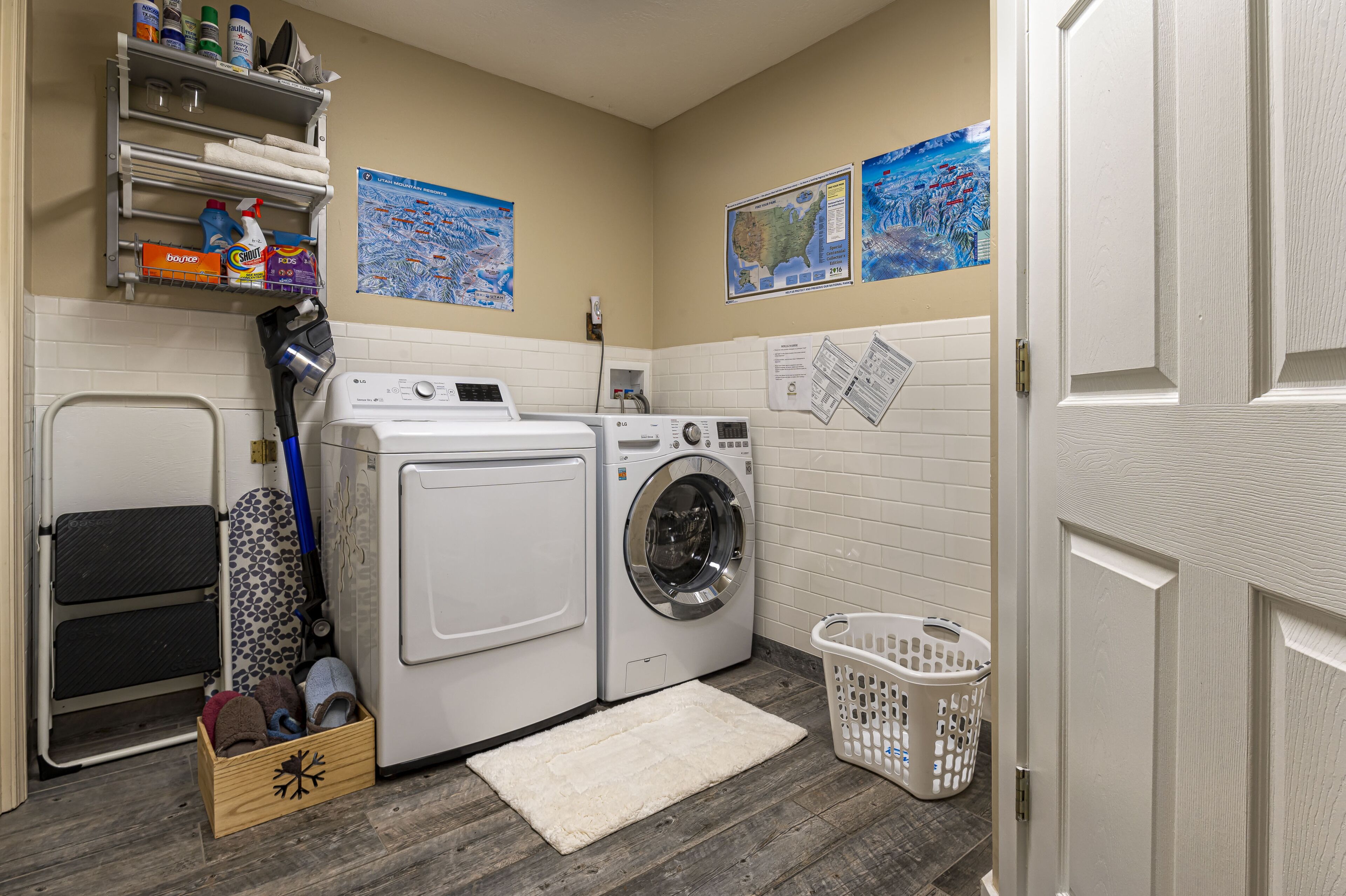 A laundry room with a washing machine, dryer, and shelves with cleaning supplies.