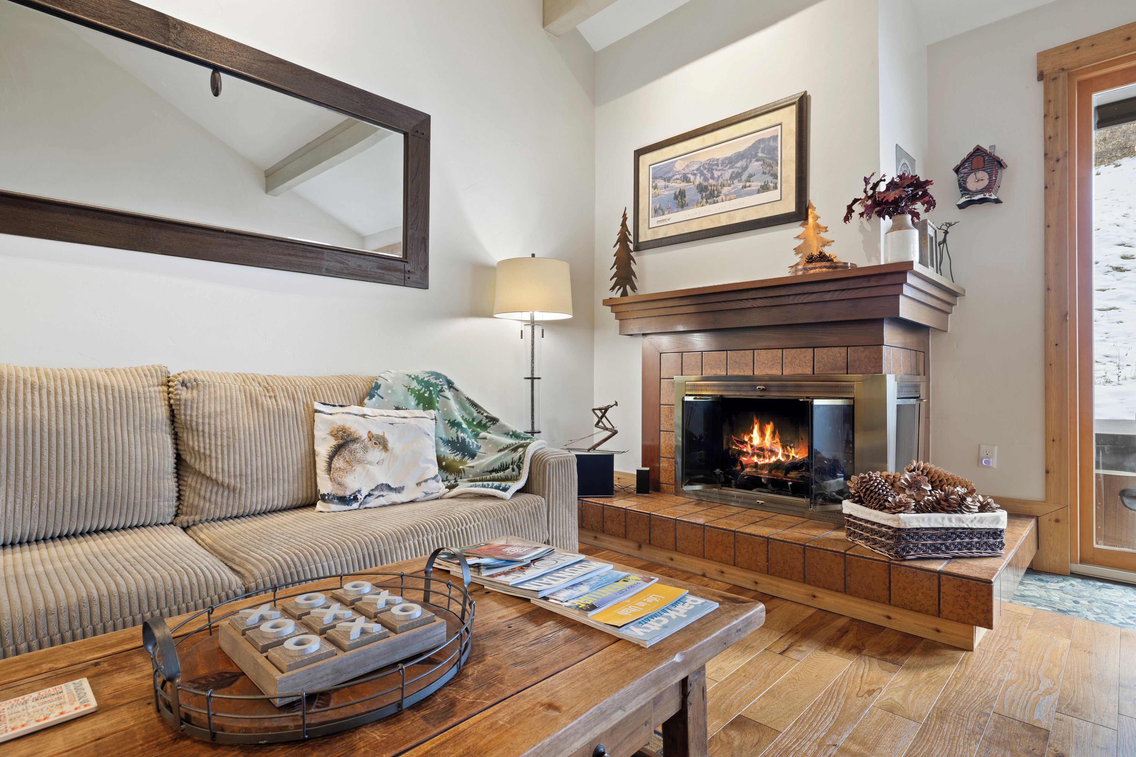 Una sala de estar acogedora con chimenea, un sofá y una mesa de centro con revistas.