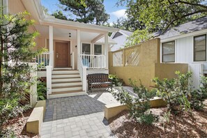 A house with a porch, a wooden door, and a small outdoor seating area.