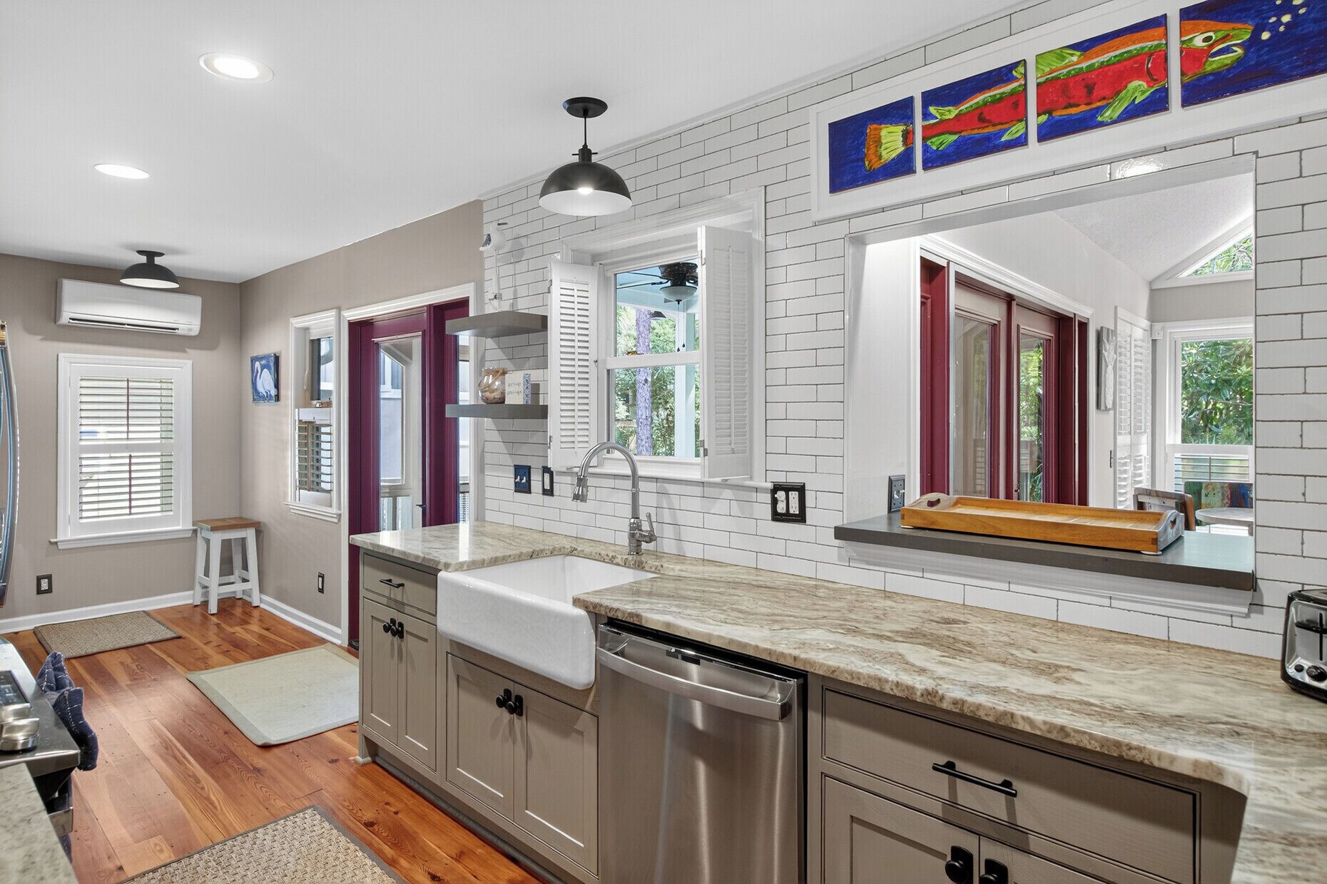 A modern kitchen with white subway tiles, stainless steel appliances, and a marble countertop.