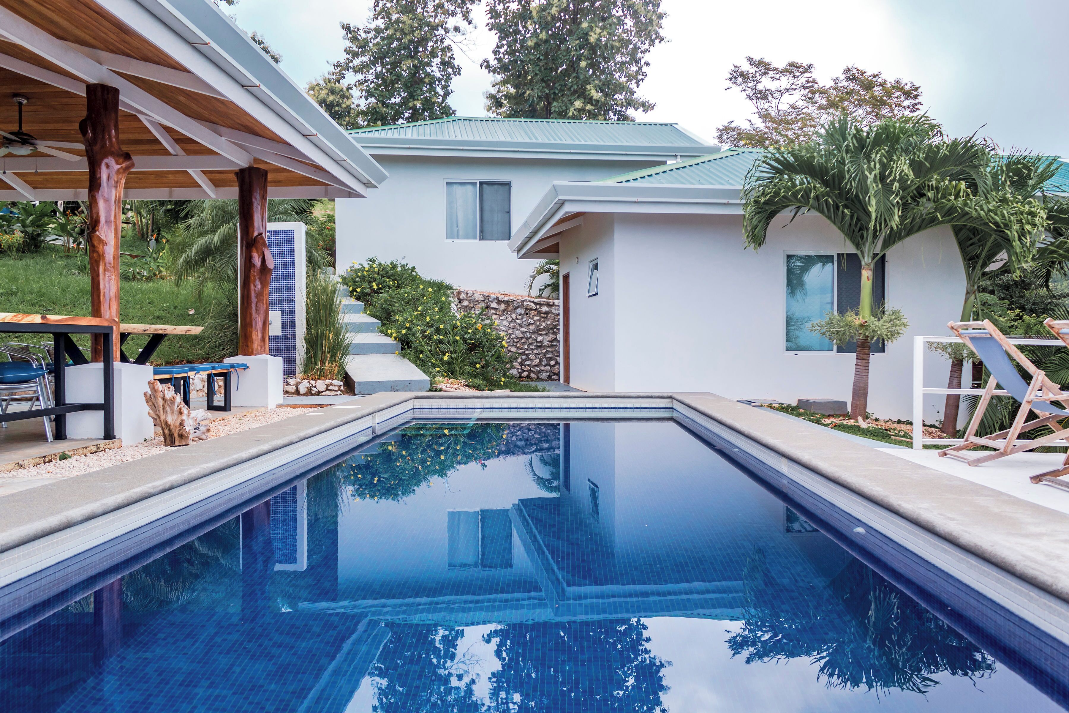 Una piscina al aire libre, sillones reclinables de piscina