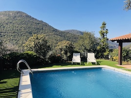 Una piscina al aire libre de temporada, sillones reclinables de piscina