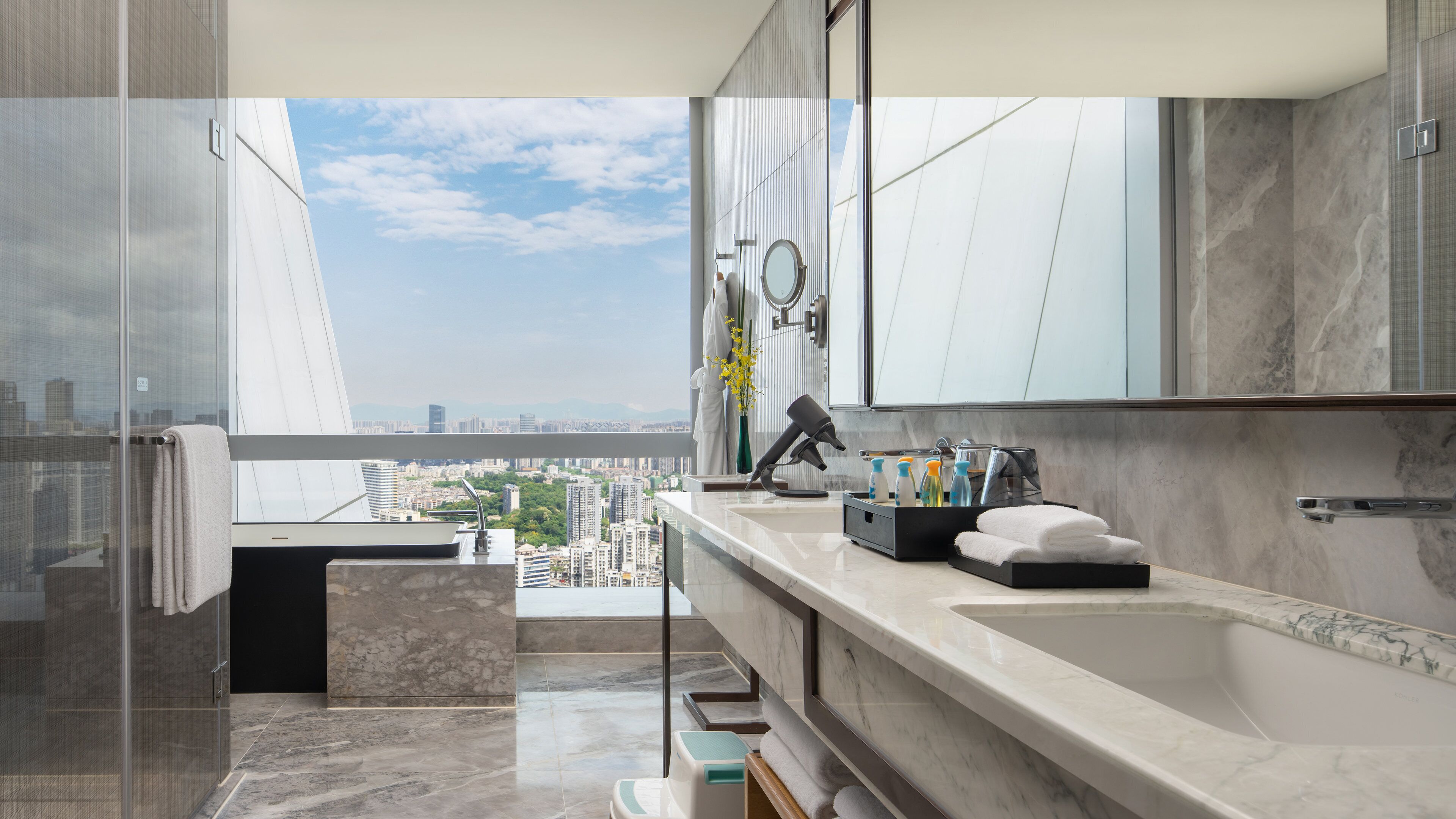 A modern bathroom with a large mirror, a sink, and a shower area.