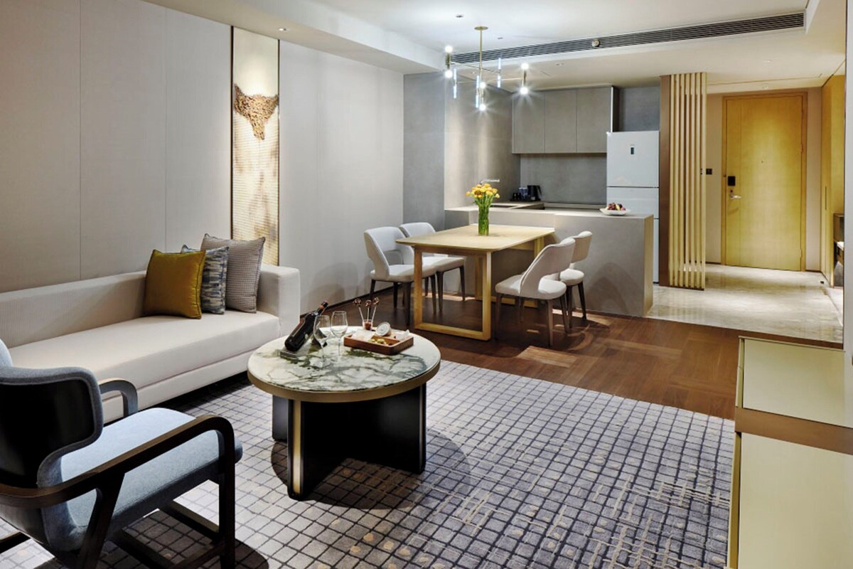 Una sala de estar moderna con un sofá, una mesa de centro y un comedor con sillas.