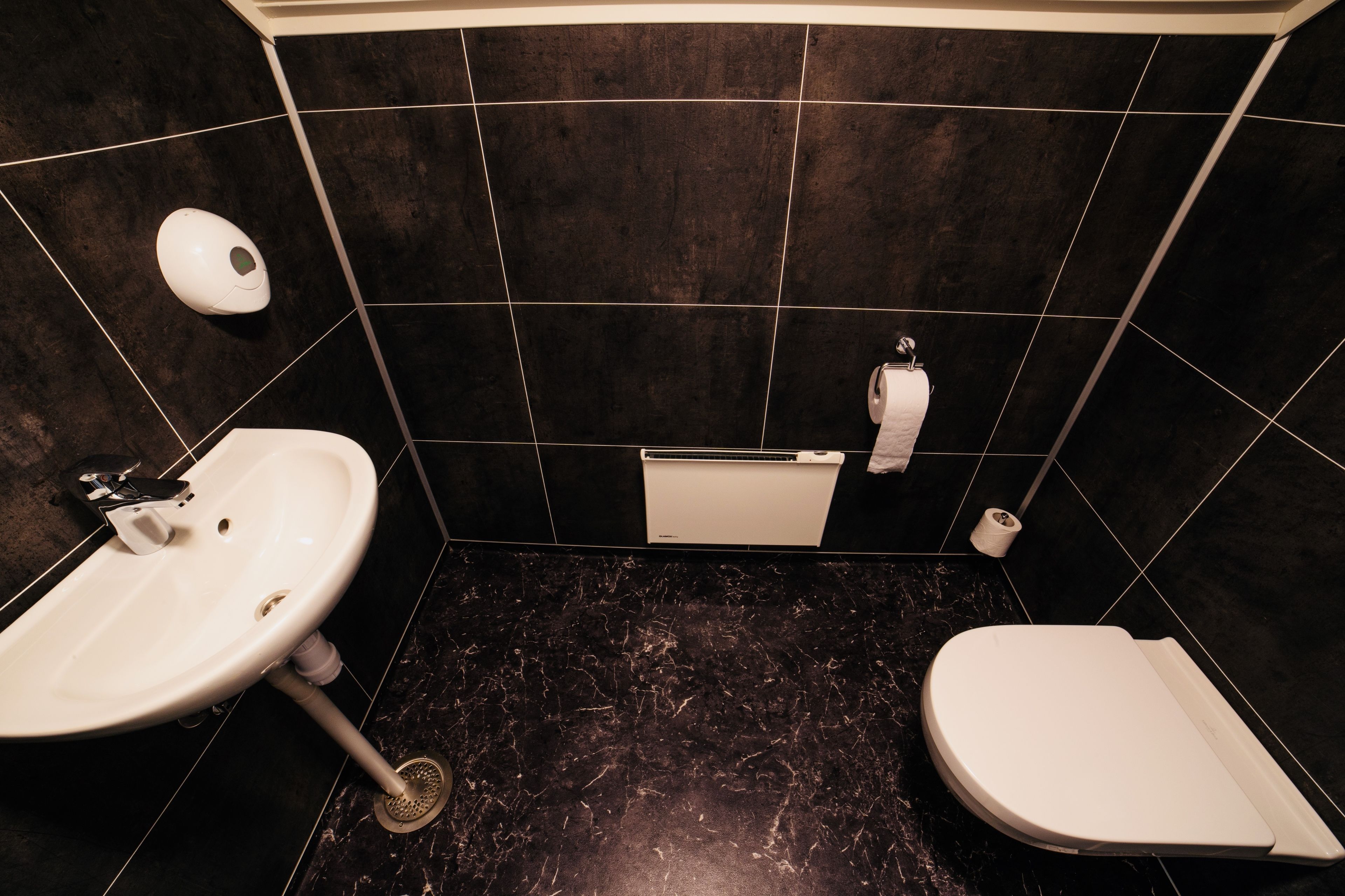 Un baño con lavamanos, inodoro y bañera blancos.