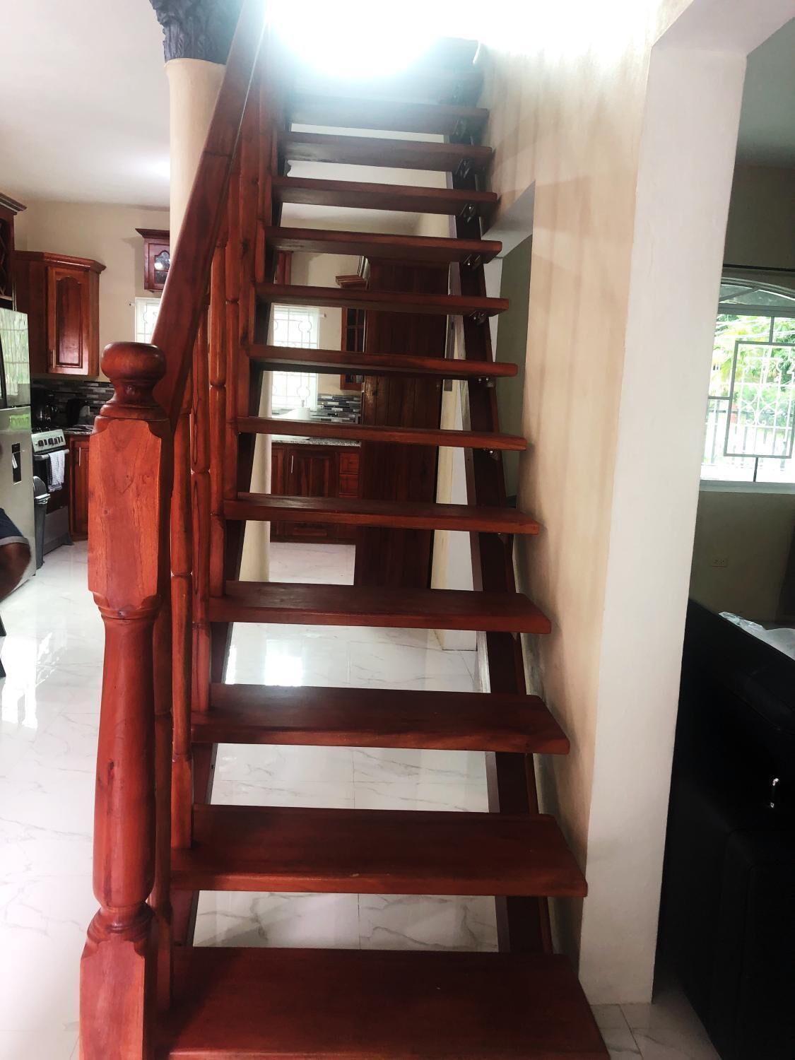 A wooden staircase with a handrail, leading to an upper floor.