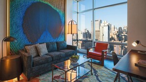 A modern living room with a city view, a large abstract painting, and contemporary furniture.