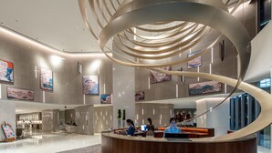 A modern lobby with a central circular light fixture, a reception desk, and artwork on the walls. - Le Méridien Hangzhou, Binjiang (Hangzhou)