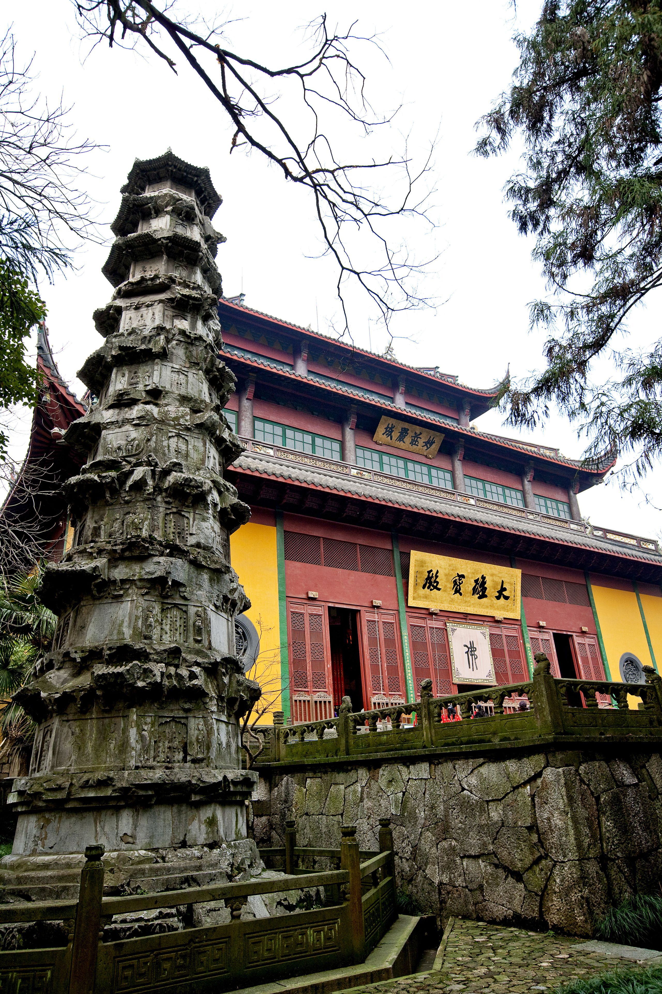 A traditional building with a multi-tiered stone structure in front.