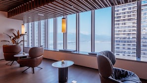 A modern lounge with a view of a bridge and buildings, featuring a wooden ceiling, large windows, and contemporary furniture. - Le Méridien Hangzhou, Binjiang (Hangzhou)