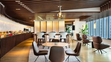 A modern interior with a long counter, round tables, and contemporary chairs.