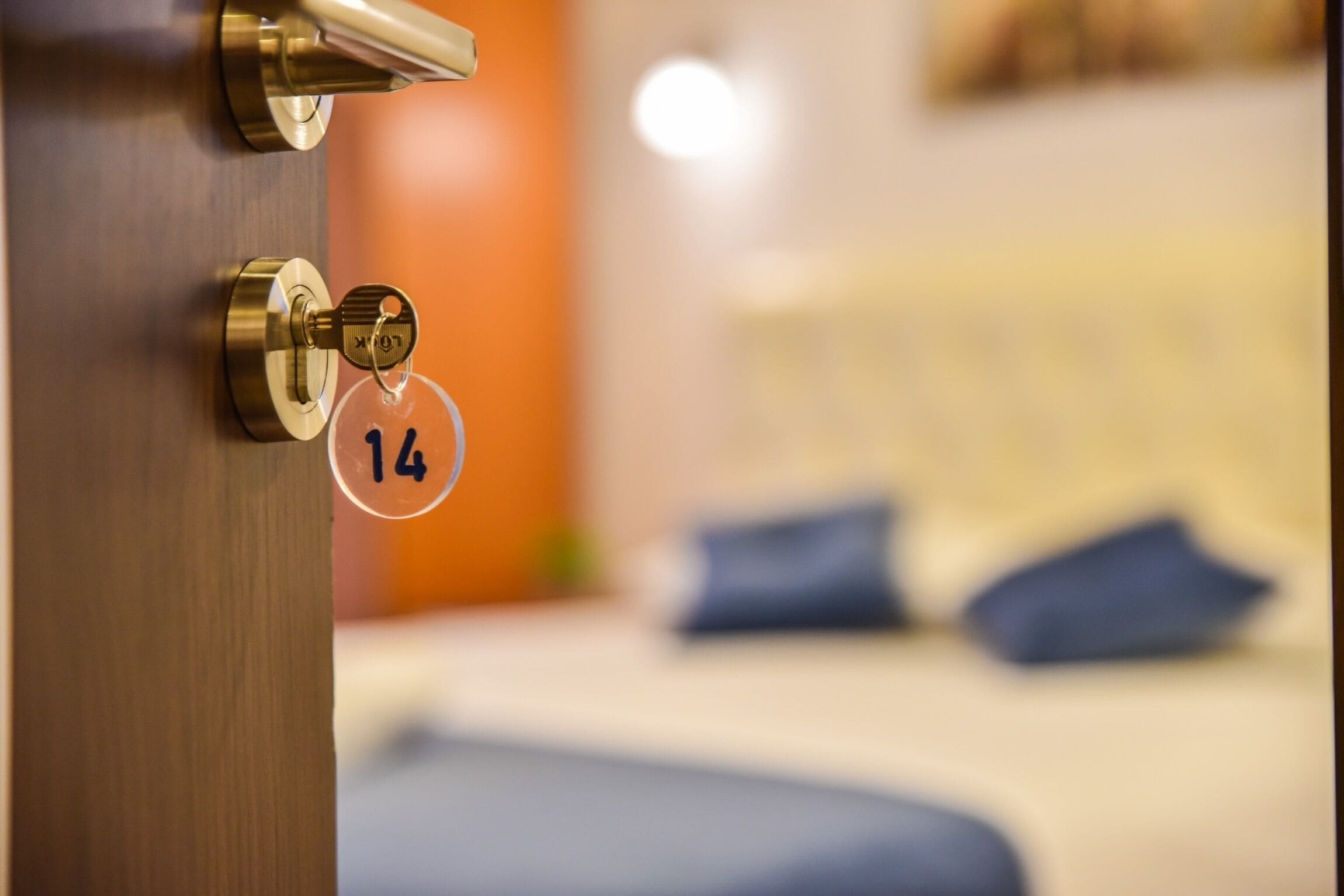 Puerta de habitación de hotel con una mirilla y un cartel con el número de la habitación.
